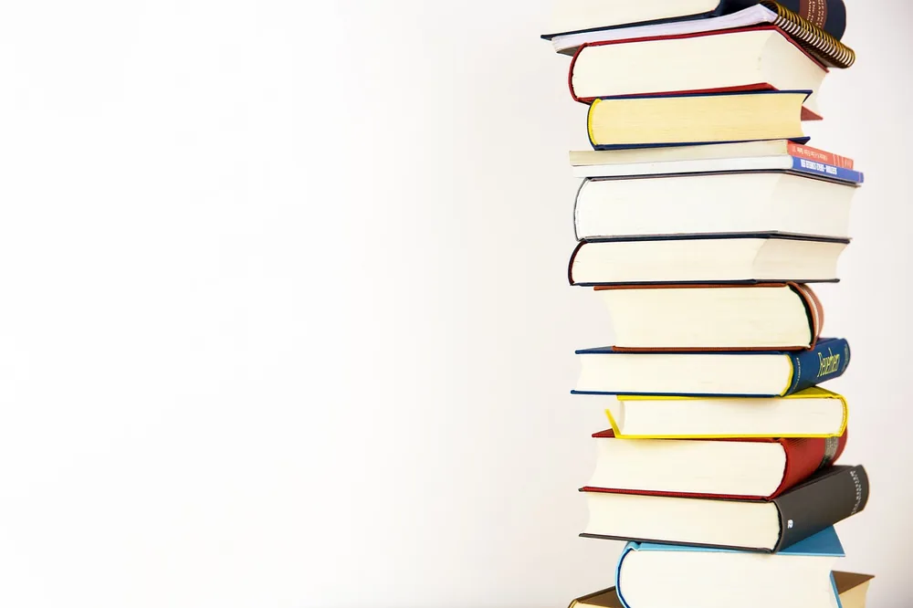 A tall stack of library books